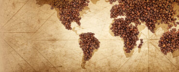 Grãos de café em cima de um mapa mundi