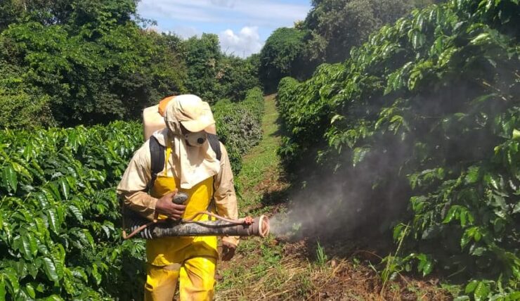 Homem realizando aplicação de produto com pulverizador costal