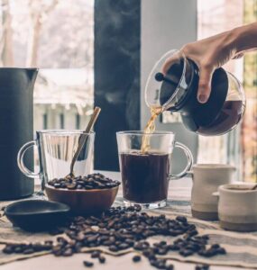 Pessoa servindo uma xícara de café