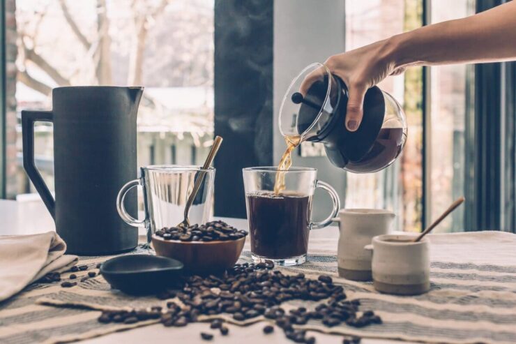 Pessoa servindo uma xícara de café