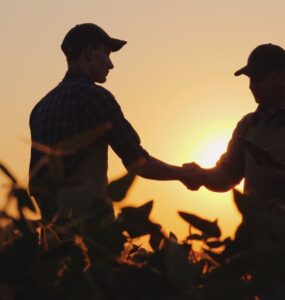 Dois homens se cumprimentando em uma fazenda