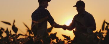 Dois homens se cumprimentando em uma fazenda