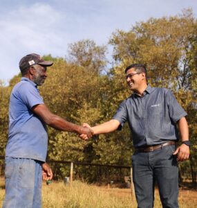 Dois homens se cumprimentando em uma propriedade rural