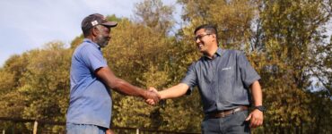 Dois homens se cumprimentando em uma propriedade rural